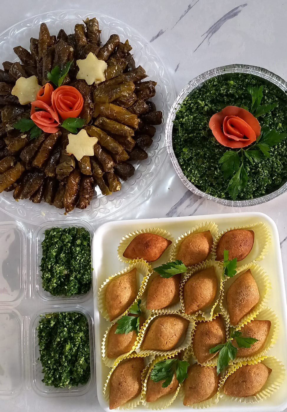 Mona Zahed prepares grape leaves, tabbouleh salad and kibbeh for delivery in August 2023 in Gaza.